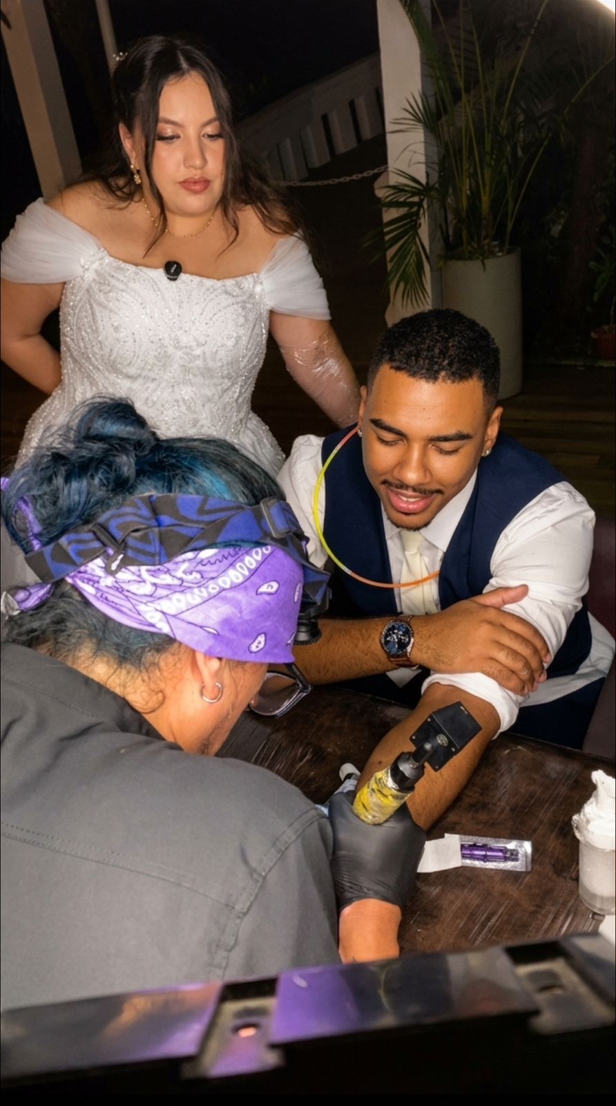 Noiva sendo tatuada com a mãe acompanhando